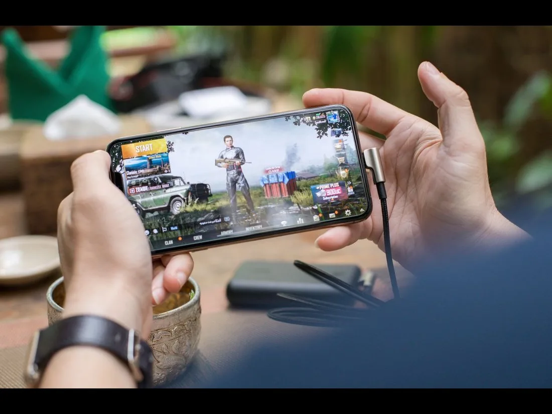 Mani che tengono uno smartphone mentre giocano a un gioco mobile